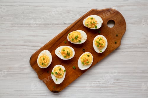Preview: Homemade Deviled Eggs With Chives On A Rustic Wooden Board On A White Wooden Table, Top View. Flat