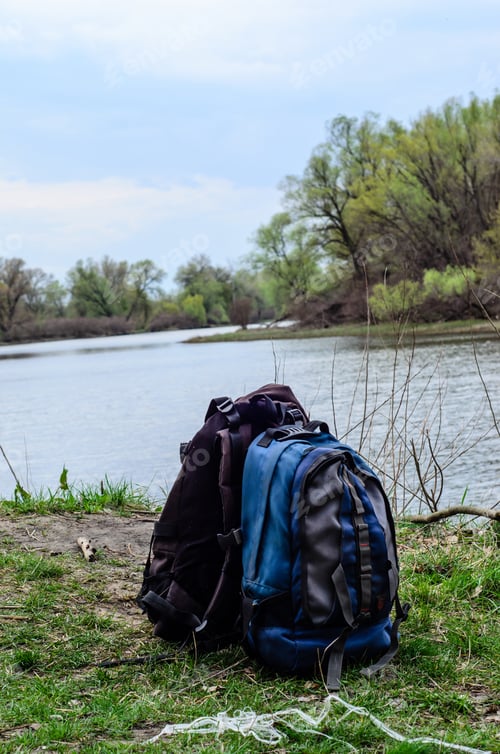 Preview: Backpacks On A Green Bank Of The River