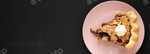 Preview: A Slice Of Homemade Chocolate Walnut Derby Pie On A Pink Plate On A Black Surface, Top View