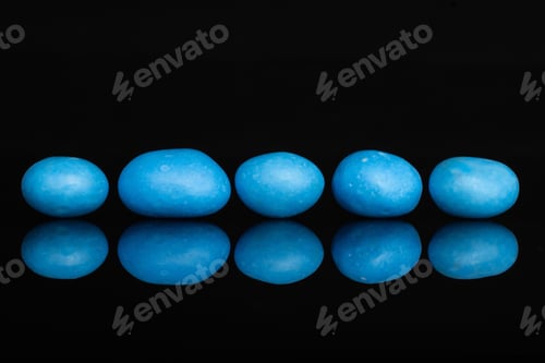 Preview: Group Of Five Whole Blue Sugared Nut Dragee Isolated On Black Glass