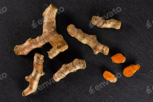 Preview: Group Of Five Whole Three Slices Of Bright Turmeric Rhizome Flatlay On Grey Stone