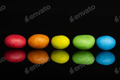 Preview: Group Of Five Whole Sugared Nut Dragee Rainbow Isolated On Black Glass
