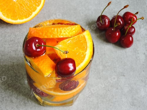 Preview: Cold Detox Water With Citrus And Cherries. Cherries With Tails. Fresh Orange.