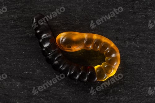 Preview: One Whole Orange Brown Colourful Jelly Worm Candy Flatlay On Grey Stone