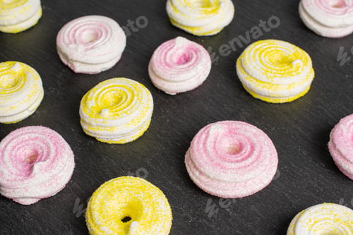 Preview: Lot Of Whole Pink And Yellow Sweet Meringue On Grey Stone