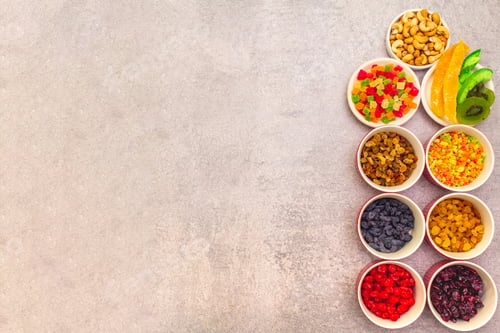 Preview: Dried And Candied Fruit And Cashew Nuts. Assorted In Ceramic Bowls On A Stone Background. Healthy