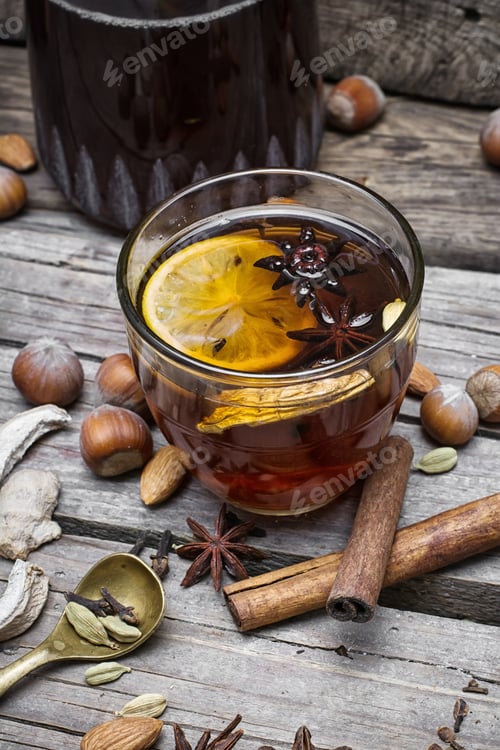 Preview: Glass Of Mulled Wine With Almonds,Cinnamon And Anise On Background Of Carafe Of Wine