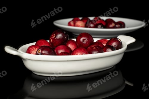 Preview: Lot Of Whole Fresh Red Cranberry On White Ceramic Plate Isolated On Black Glass