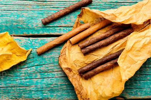 Preview: Cigarillos And Dry Tobacco Leaf On Wooden Background