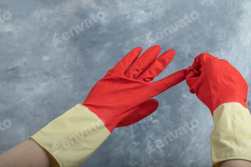 Preview: Hands Taking Off Red Protective Gloves On Marble Background