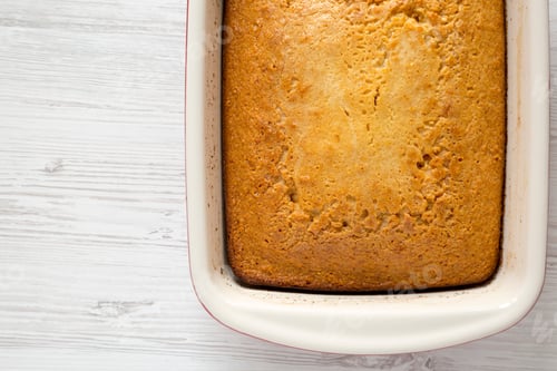 Preview: Homemade Sweet Cornbread In A Dish Over White Wooden Surface, Top View. Flat Lay, Overhead, From