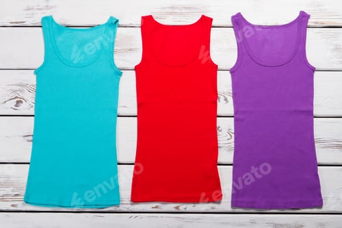 Preview: Multicolored Knitted Tops On A Wooden Background. Summer Women'S T-Shirts For Every Day.