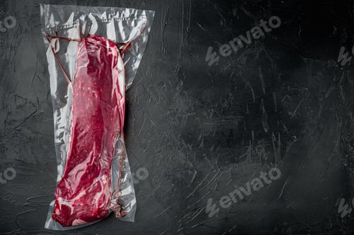 Preview: Raw Beef Tenderloin Marbled Meat In Plastic Pack Set, On Black Stone Background, Top View Flat Lay
