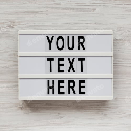 Preview: 'Your Text Here' Words On A Lightbox On A White Wooden Surface, Top View. Flat Lay, Overhead.