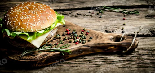 Preview: Burger On An Old Wooden Board With Spices. On Wooden Background.