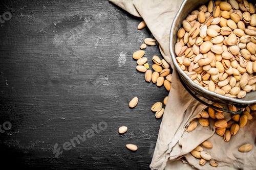 Preview: Pistachios In An Old Bucket On The Fabric. On A Black Chalkboard.