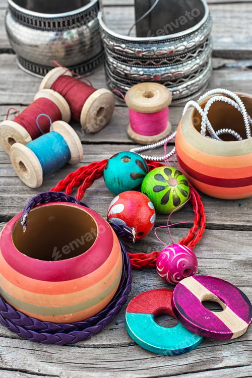 Preview: Stylish Beads And Spools Of Thread On Wooden Background