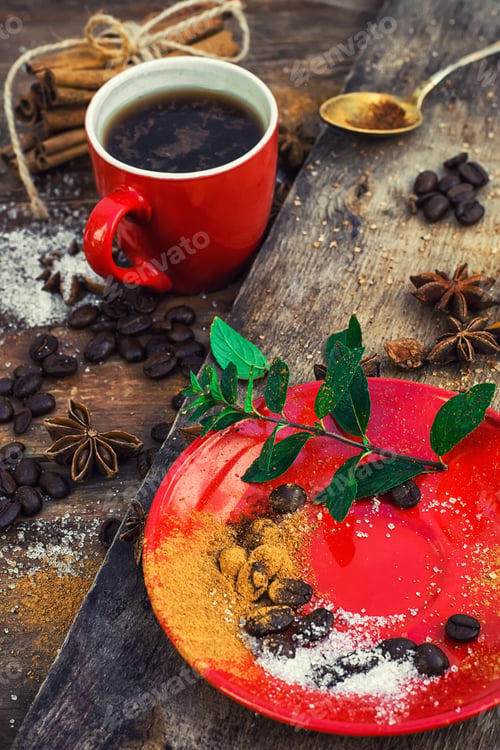 Preview: Red Glass Cup With Coffee On Wooden Background Strewn With Aromatic Spices To Drink