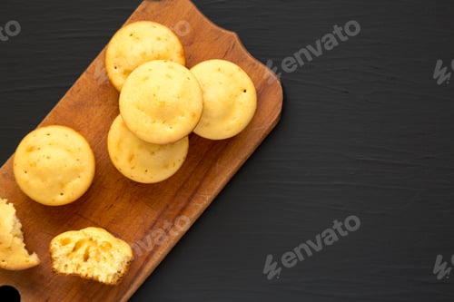 Preview: Homemade Cornbread Muffins On A Rustic Wooden Board On A Black Surface, Top View. Flat Lay