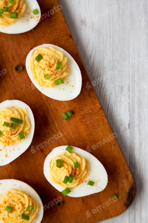 Preview: Homemade Deviled Eggs With Chives On A Rustic Wooden Board On A White Wooden Table, Top View. Flat
