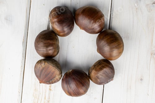 Preview: Group Of Seven Whole Edible Brown Chestnut Circle Flatlay On White Wood