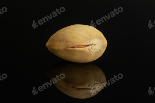 Preview: One Whole Closed Ripe Green Pistachio In Closeup Isolated On Black Glass