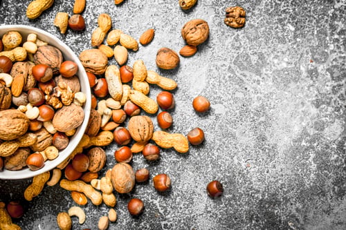 Preview: Different Nuts In A Bowl. On Rustic Background.