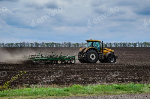 Preview: Tractor Cultivating Field On Cloudy Spring Day