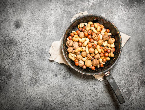 Preview: Different Nuts In A Frying Pan. On Rustic Background.