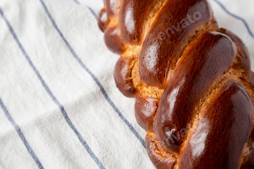 Preview: Homemade Jewish Challah Bread On A White Wooden Surface, Side View. Copy Space.