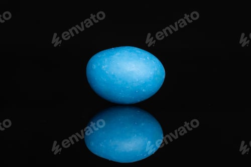 Preview: One Whole Blue Sugared Nut Dragee Isolated On Black Glass
