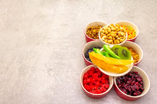 Preview: Dried And Candied Fruit And Cashew Nuts. Assorted In Ceramic Bowls On A Stone Background. Healthy