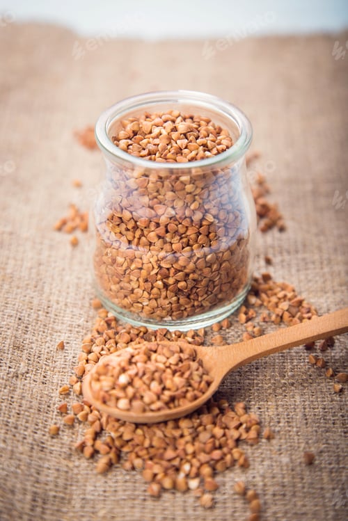 Preview: Buckwheat Groats In Glass Container With A Wooden Spoon In A Studio
