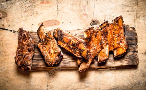 Preview: Pork Ribs Grilled On The Old Board. On A Wooden Table.