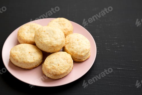 Preview: Homemade Flaky Buttermilk Biscuits On A Pink Plate On A Black Background, Side View. Copy Space.