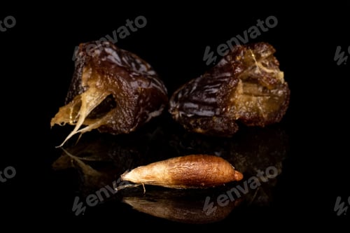 Preview: Group Of Two Halves One Piece Of Dried Brown Date Fruit Isolated On Black Glass