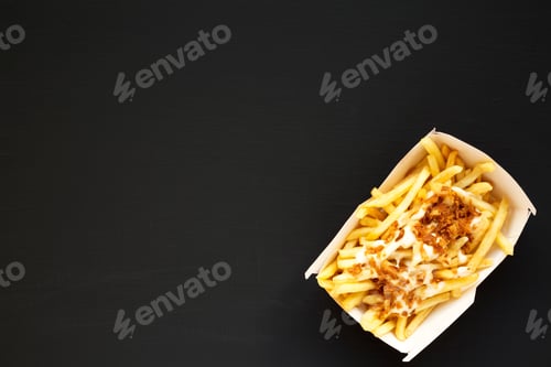 Preview: Top View, French Fries With Cheese Sauce And Onion In A Paper Box On A Black Background. Flat Lay