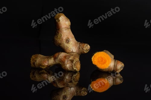Preview: Group Of Two Whole One Half Of Pungent Bright Turmeric Rhizome Isolated On Black Glass