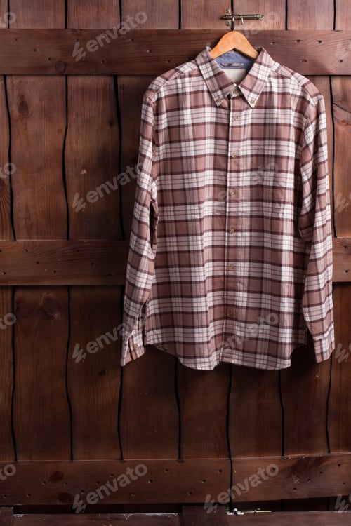 Preview: Fitting Room In A Clothing Store. Checkered Shirt Is Hanging On A Wooden Fence. Shirt Of Cowboy.
