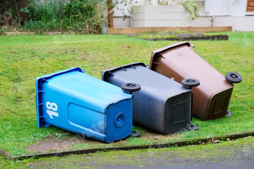 Preview: Wheelie Bins Blue Black And Brown In Garden Fallen Over On Side