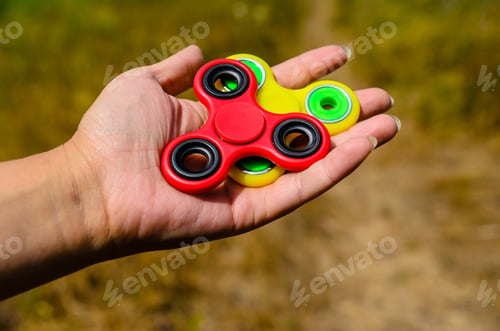 Preview: Red And Yellow Fidget Spinners In A Female Hand