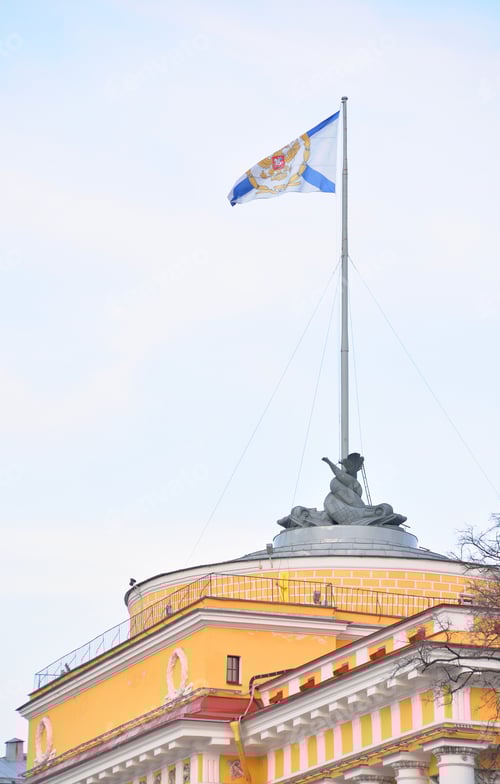 Preview: Yellow Building with Mermaid Statue and Decorative Flag