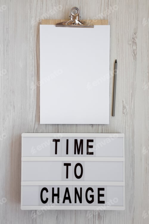 Preview: 'Time To Change' Words On A Modern Board, Clipboard With Blank Sheet Of Paper On A White Wooden