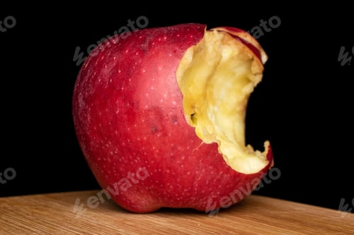 Preview: One Whole Bitten Fresh Apple Red Delicious On Bamboo Cutting Board Isolated On Black Glass