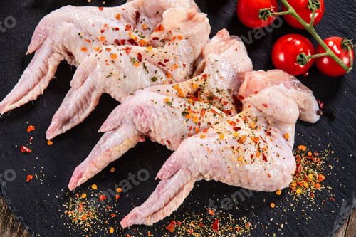 Preview: Raw Chicken Wings On Black Stone On Wooden Background