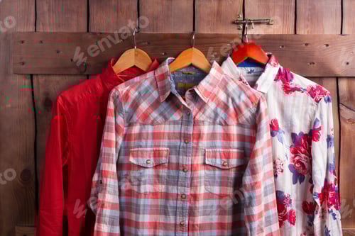 Preview: Different Bright Shirts On A Wooden Fence In A Fitting Room.