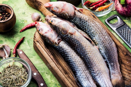 Preview: Fresh Raw Fish On Wooden Cutting Board.Raw Fish With Spices For Cooking.Fish Background