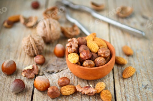Preview: Mixed Nuts In A Bowl On A Wooden Background. Almond, Hazelnut And Walnut. Nuts In A Clay Bowl On