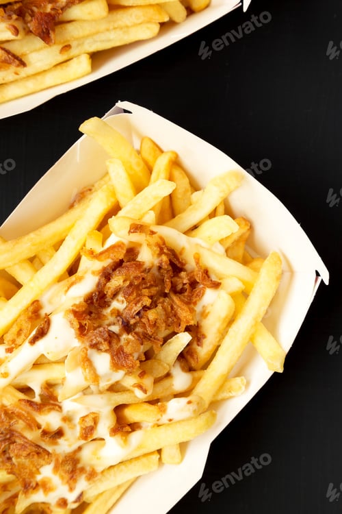 Preview: French Fries With Cheese Sauce And Fried Onion In Paper Boxes On A Black Surface, Top View. Flat