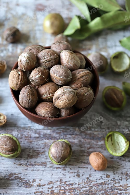 Preview: Selective Focus. Walnuts In A Bowl. Walnut Leaves Walnuts In A Green Peel. Harvest Walnuts.